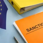 European Union flag beside an orange document folder labeled Sanctions, representing EU policy and secondary sanctions enforcement.