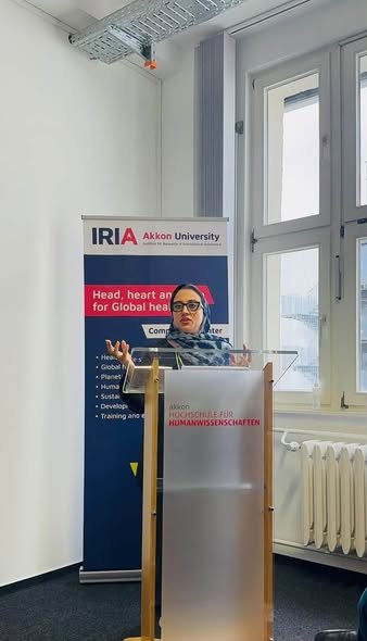 Dr. Farhat Asif delivering the keynote address at the lectern at Akkon University in Berlin